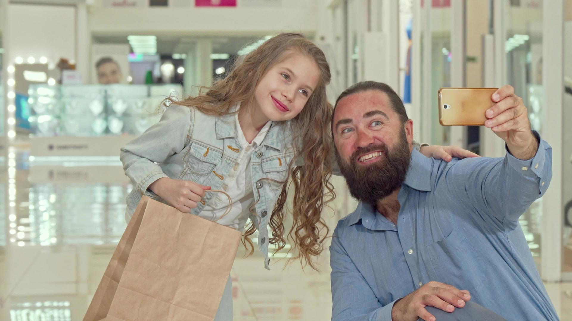 这个可爱的小女孩和她的父亲在购物中心和购物中心自拍视频的预览图