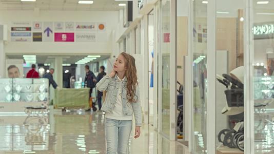 可爱的小女孩带着购物袋在商场散步视频的预览图