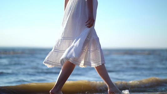 一个穿着白裙子的女人躺在海上休息她穿着白色衣服躺在海里视频的预览图