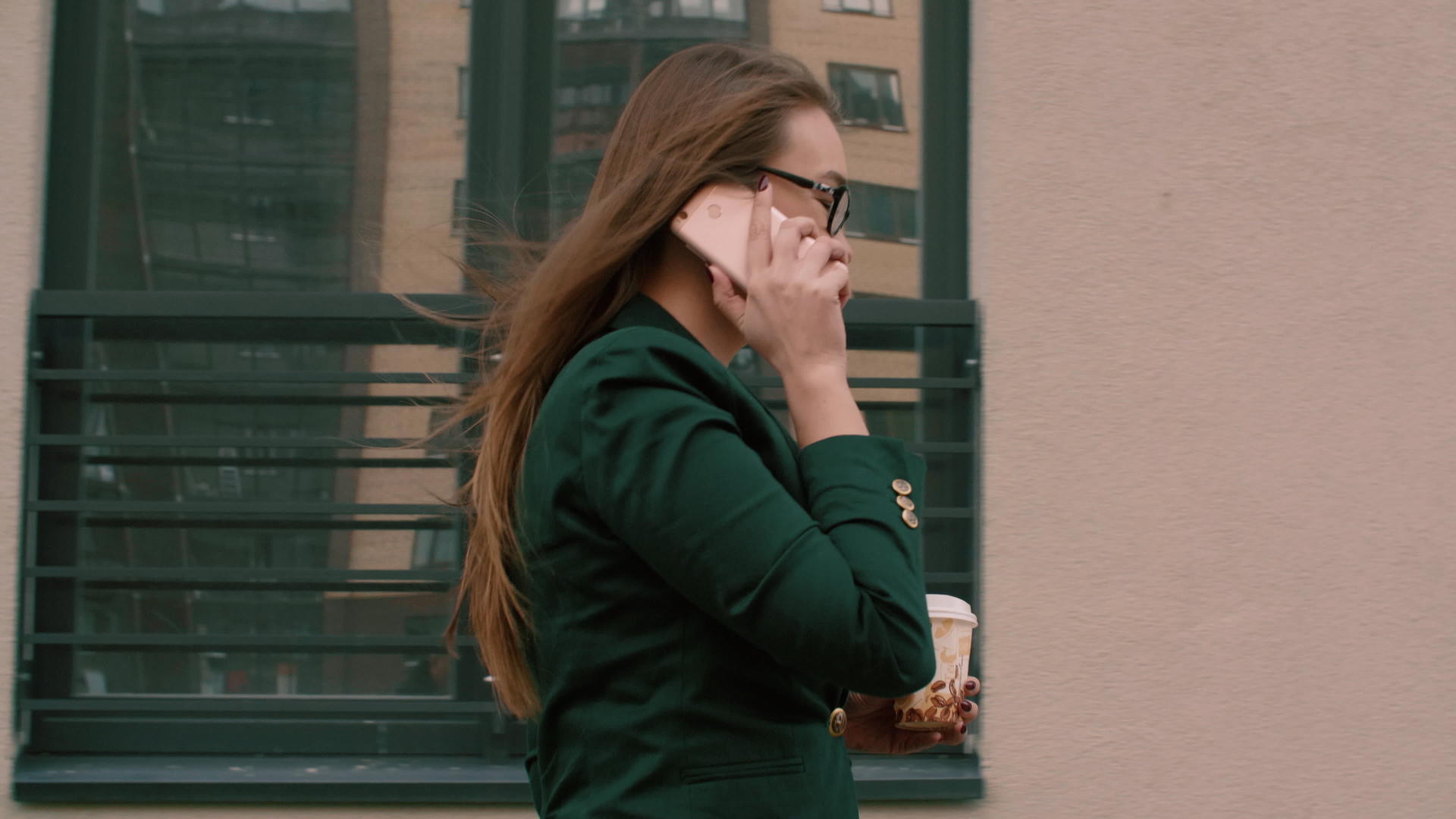 成功的商业女性商人咖啡是用来通过电话交谈和在办公楼上行走的视频的预览图