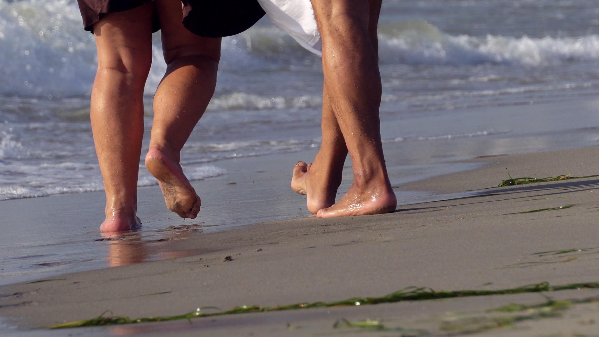 已婚浪漫的夫妇赤脚在海滩上行走视频的预览图