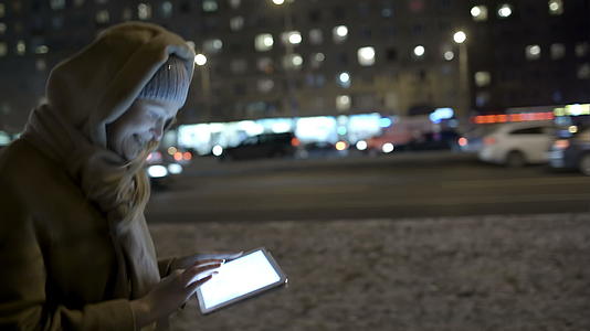 女人晚上走路时在墙上打字视频的预览图