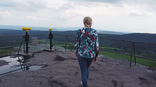 女人走在山顶的景点上视频的预览图
