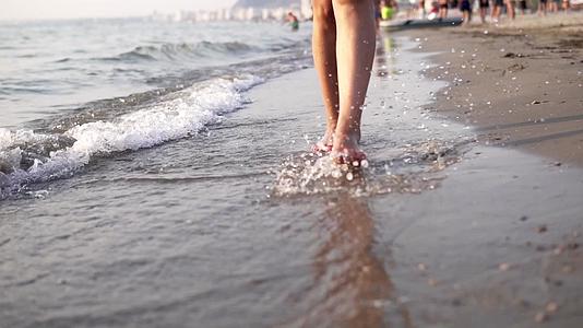 夏天闭着脚的女人在海边慢慢地散步视频的预览图