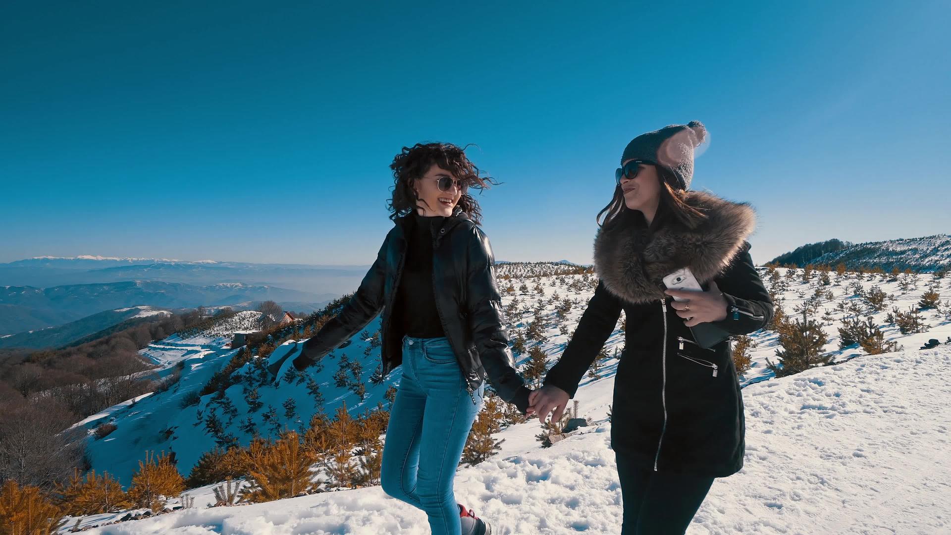在山上的冬雪上两个美丽快乐的青少年微笑着在电影里视频的预览图
