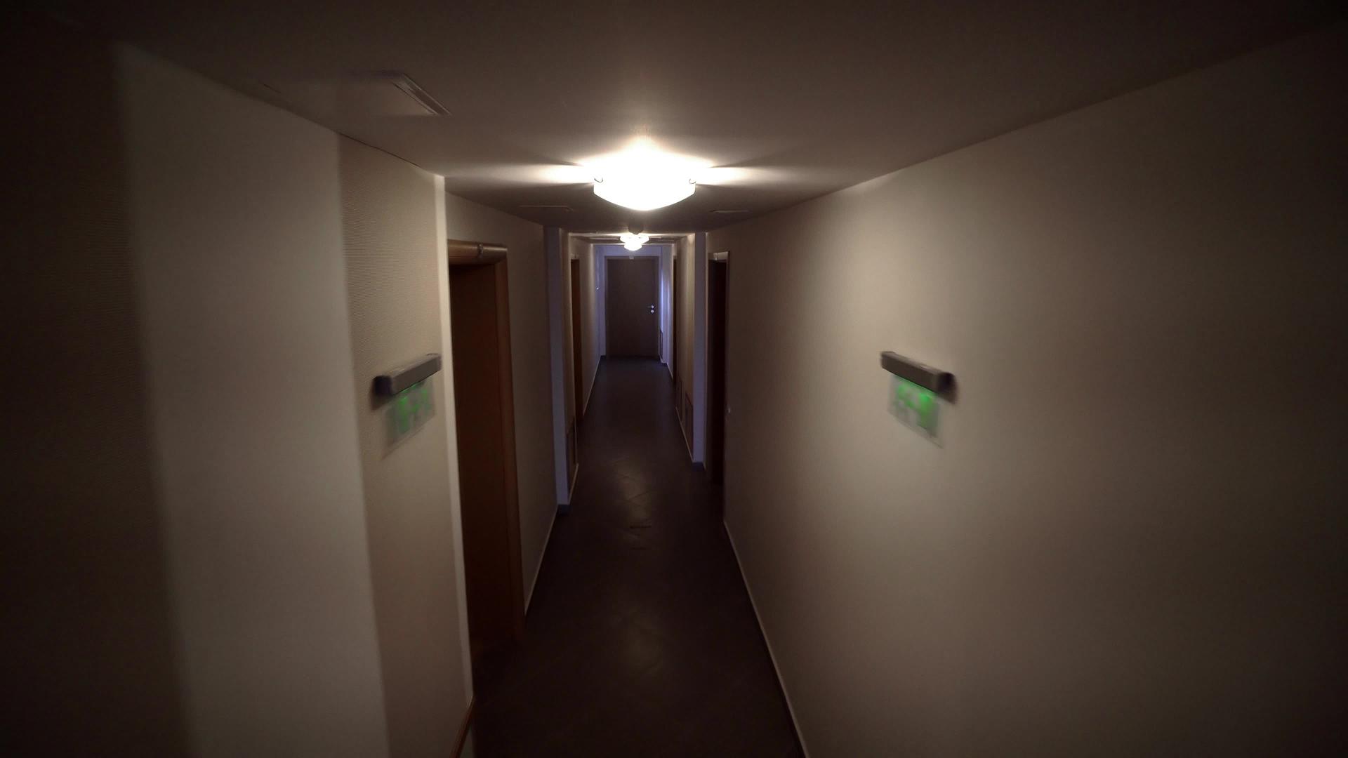 公寓楼的旧暗走廊追踪到旧公寓楼走廊的公寓门Cinematci视频的预览图