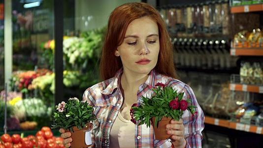 在超市里女人闻到不同家庭植物的气味视频的预览图