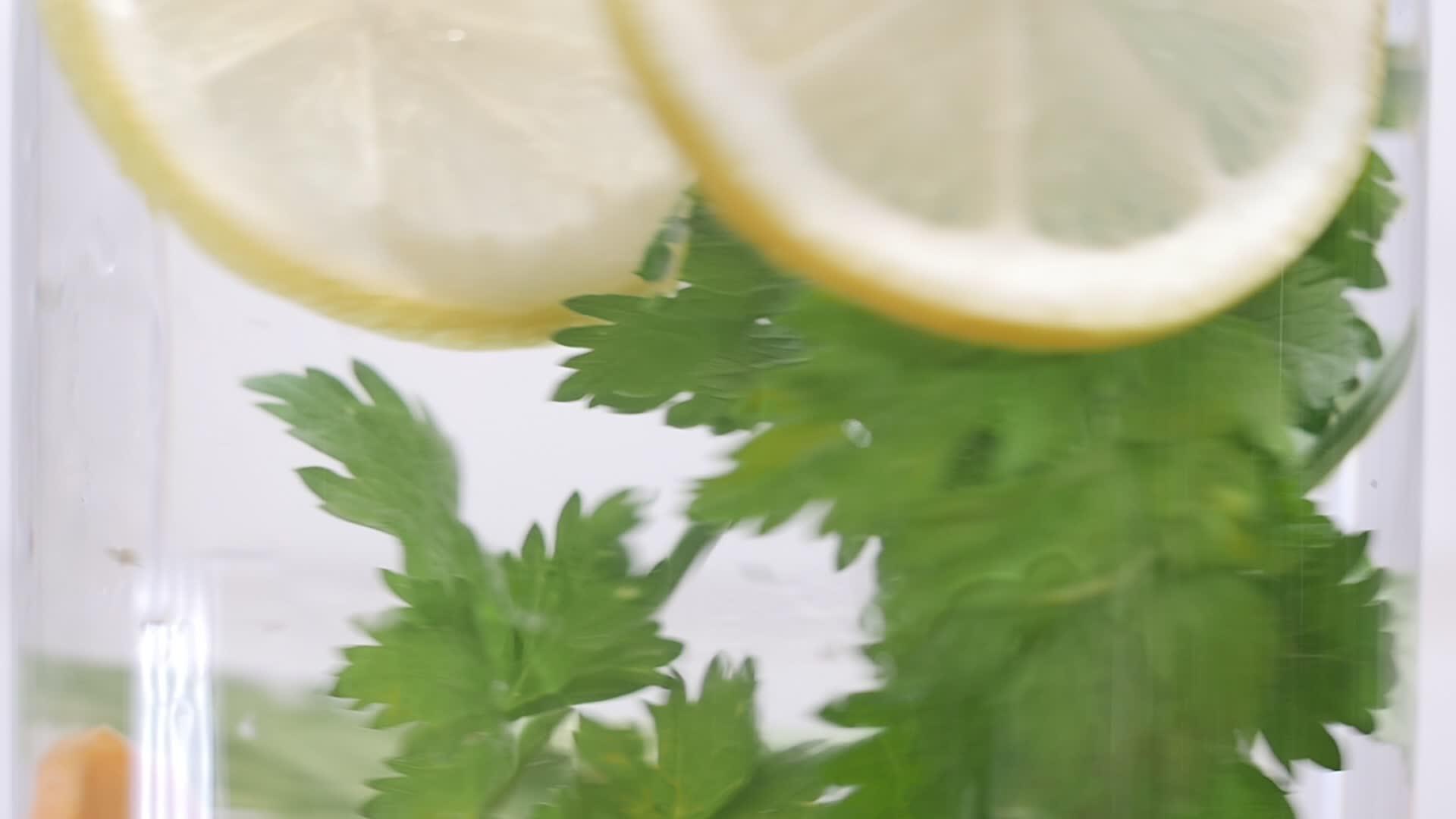 新鲜的有机胡萝卜雪莱和柠檬倒入玻璃中用水清洗玻璃视频的预览图