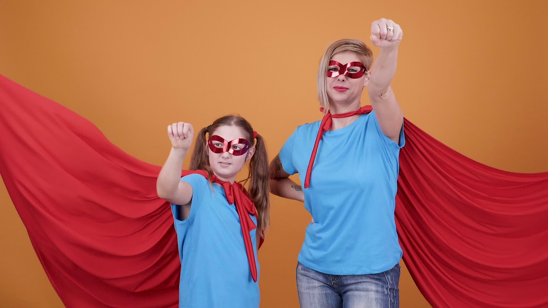 一个年轻的女孩和一个女人在橙色的背景下成为了超级英雄视频的预览图