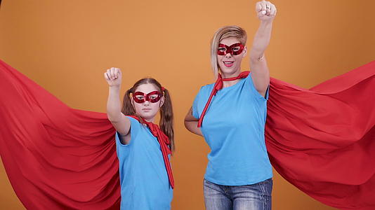 年轻女孩和母亲假扮成超级超级英雄飞翔视频的预览图