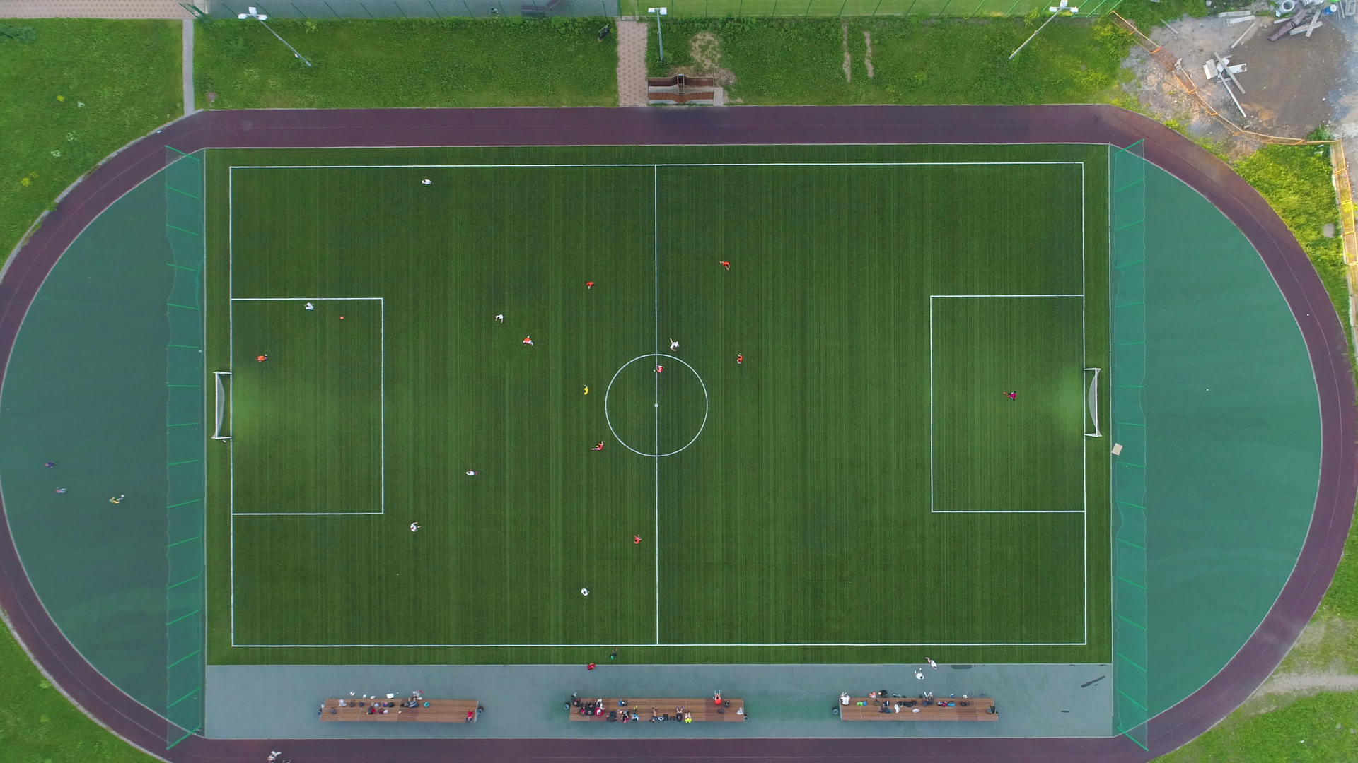 飞过绿色足球场的中心球员们在空中垂直高视地踢球视频的预览图