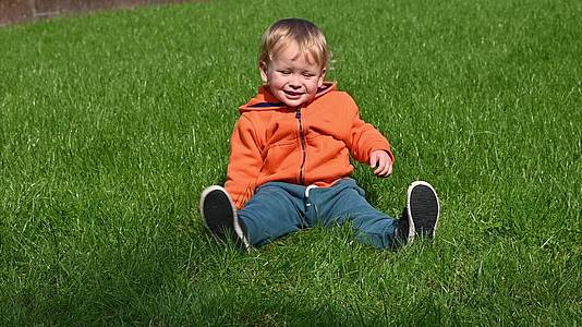 小男孩在草地上踢足球视频的预览图