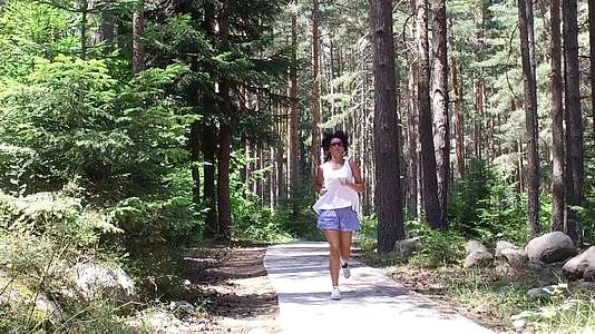 年轻美女在森林里慢跑慢跑前直飞视频的预览图
