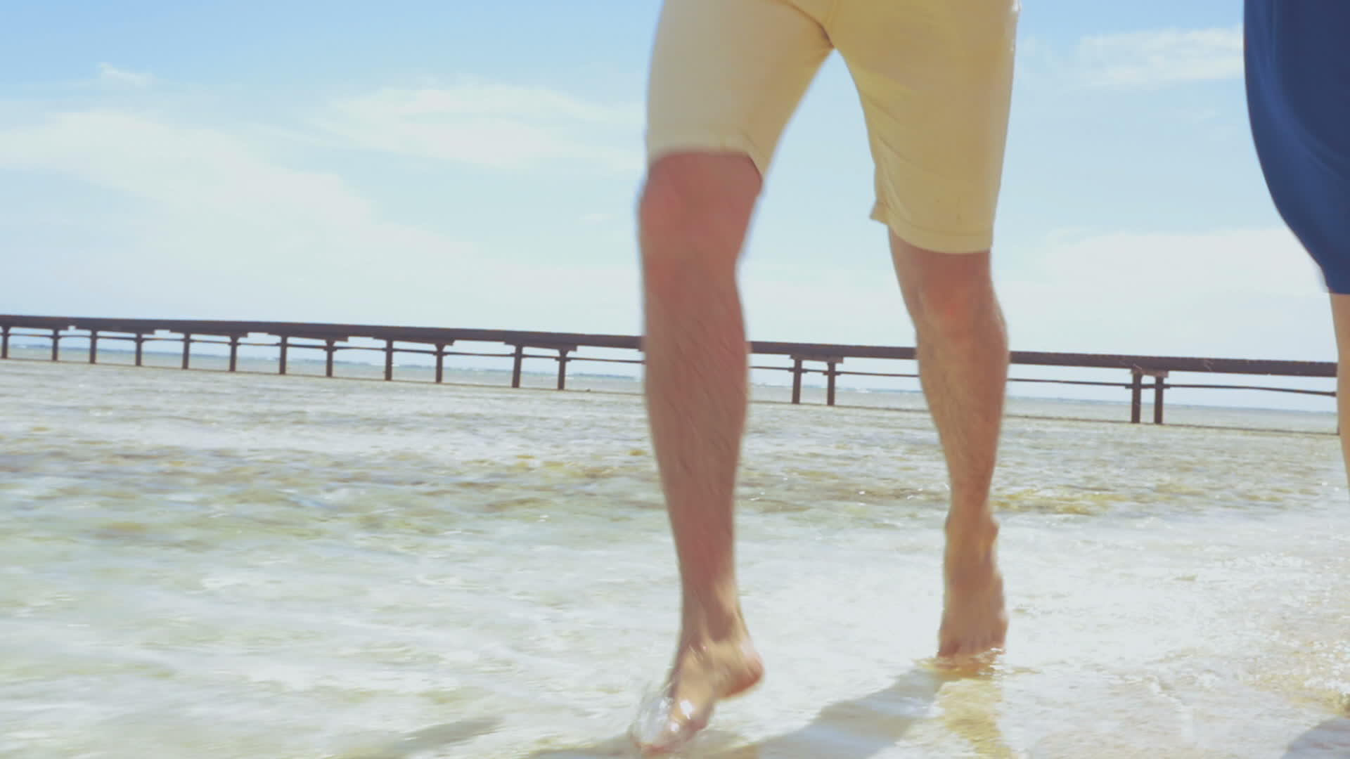 赤脚夫妇在浅水海滩上奔跑视频的预览图