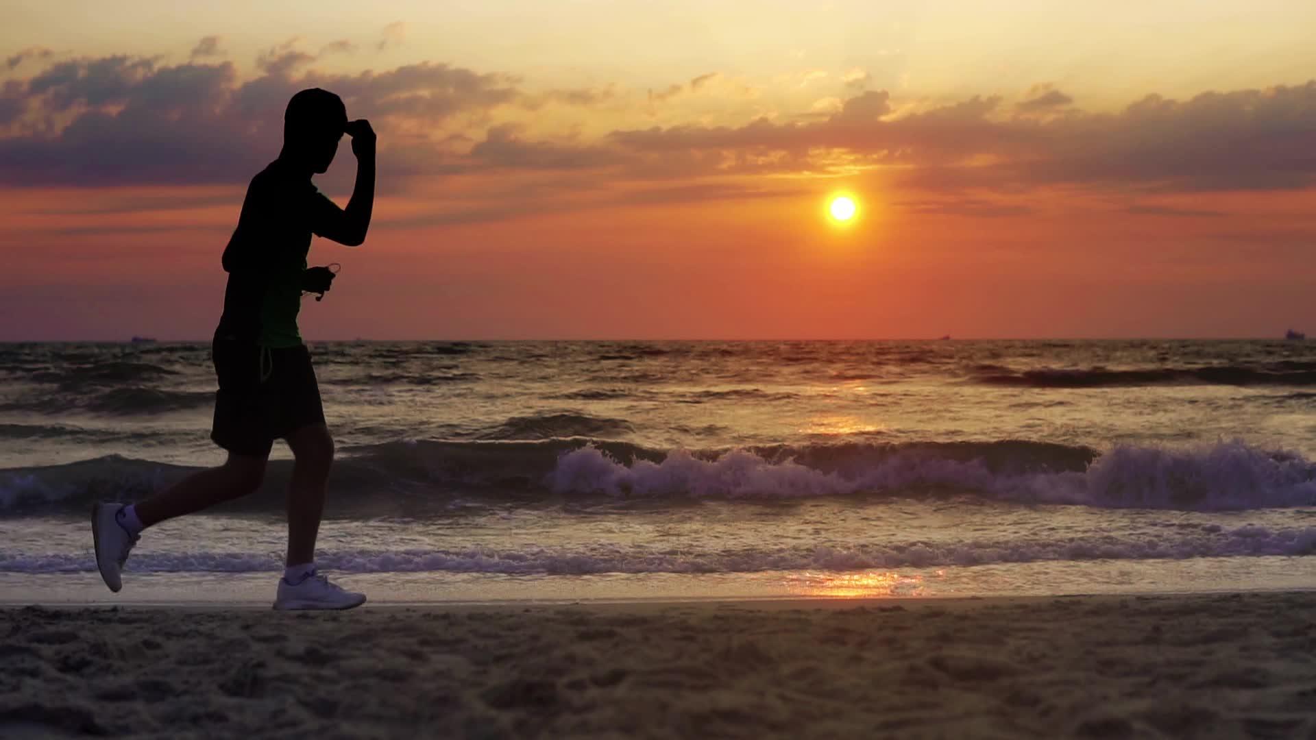 日落时在海边慢跑的人慢慢移动视频的预览图