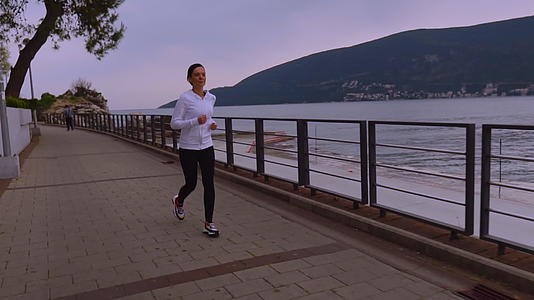 女人在山脚下的山上奔跑视频的预览图