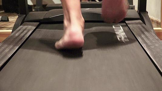 在健身房的跑步机上步行锻炼——健身生活方式、技术和技术视频的预览图
