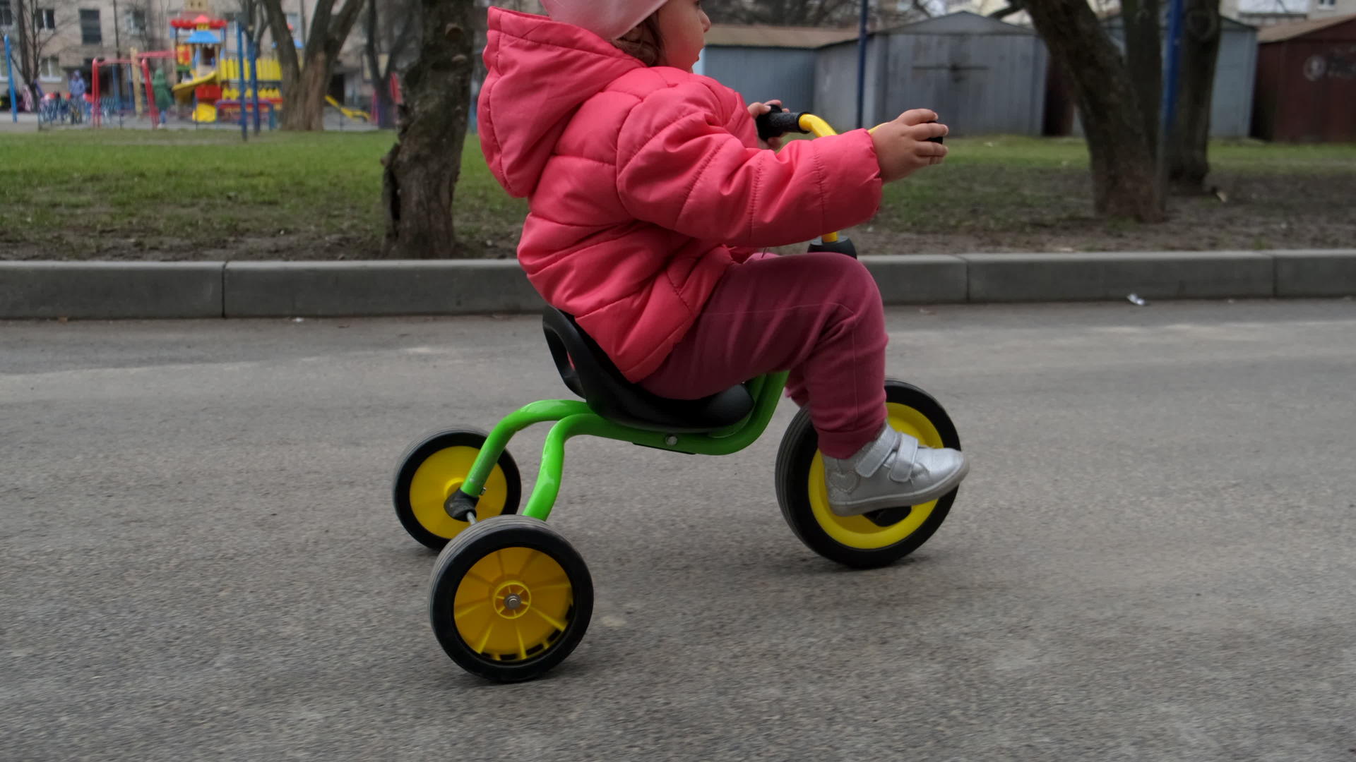 在街上骑三轮车的孩子和女孩侧视着视频的预览图