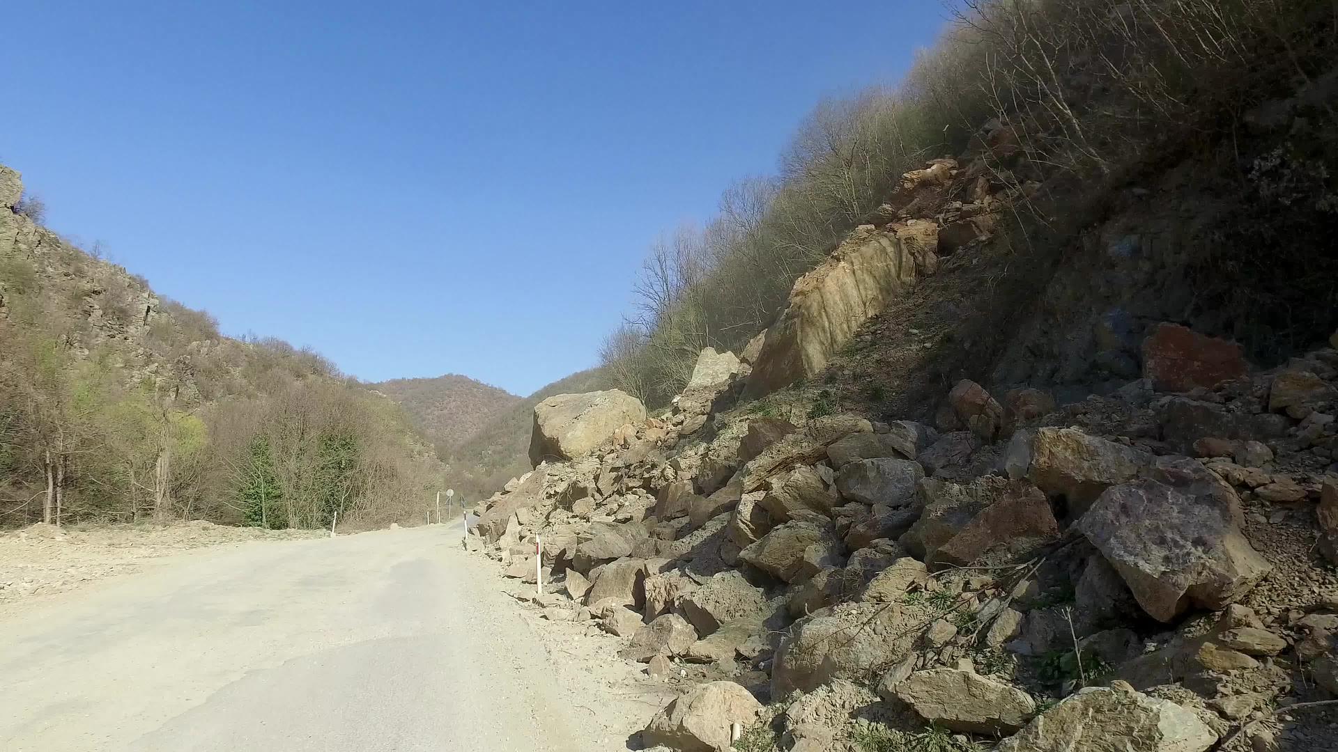道路被岩石和碎片的滑坡挡住对汽车司机构成危险视频的预览图