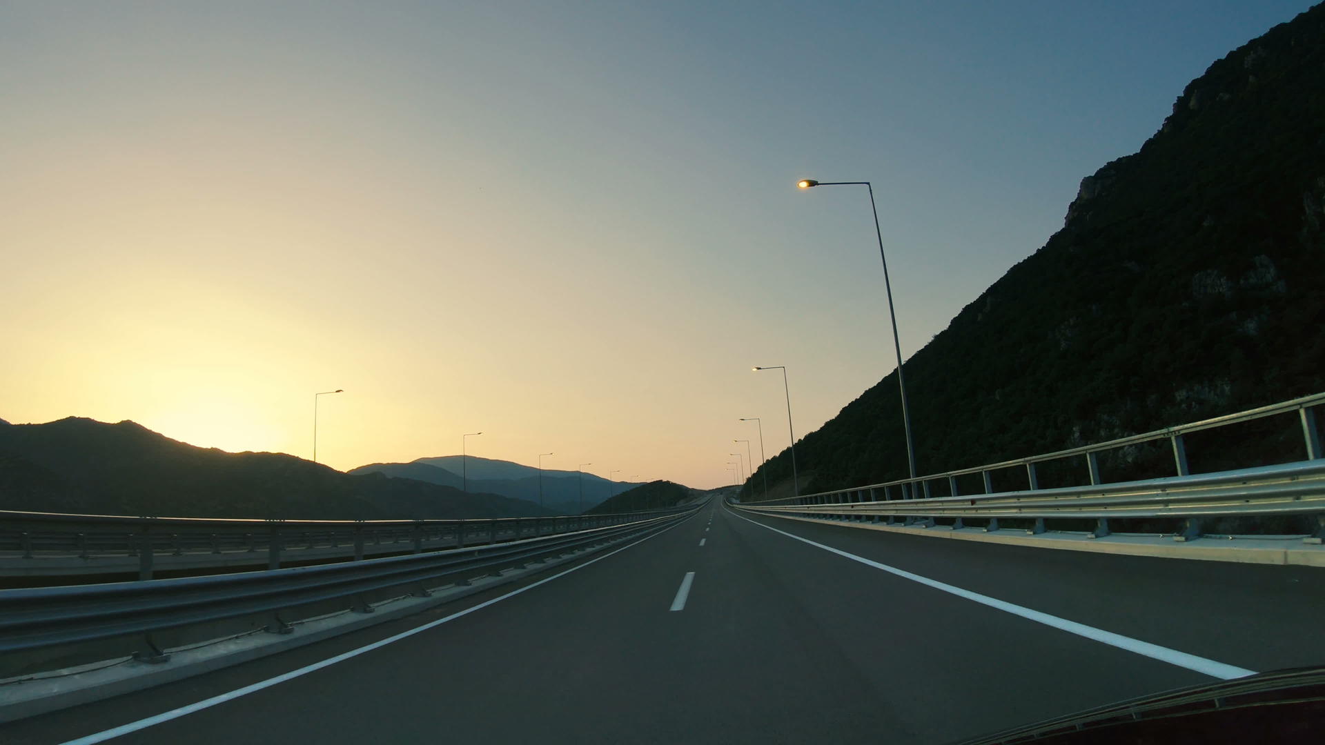 在高速公路上驾驶第一视角的山路景观和晴朗的岩石天空和云彩视频的预览图