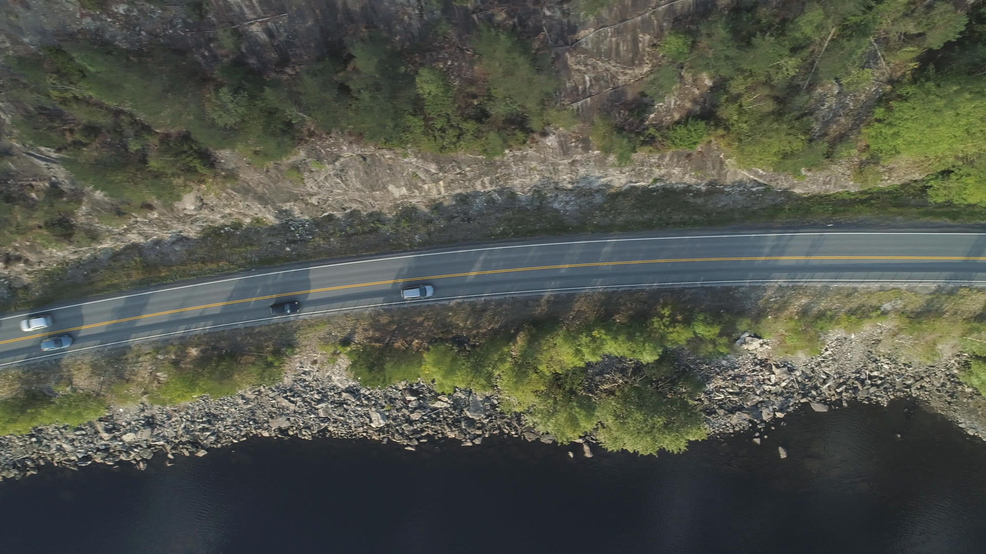 在夏天阳光明媚的日子里汽车在挪威湖附近的乡村道路上视频的预览图