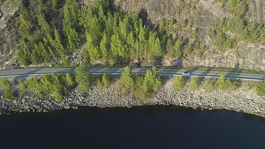 在阳光明媚的夏天白色的汽车在挪威湖附近的乡村视频的预览图