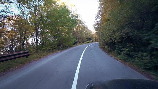 秋黄树间山村公路上的车辆视频的预览图