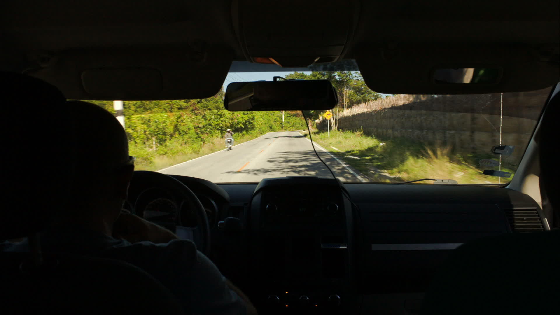 在乡村路上开车周围有许多绿树视频的预览图