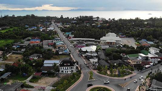 汽车骑在丛林附近小镇的环形十字路口泰国苏梅岛小镇中部视频的预览图