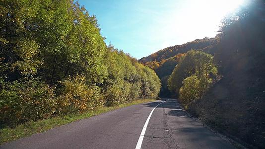 从司机的角度来看山路在秋天穿过一条蜿蜒的山路视频的预览图