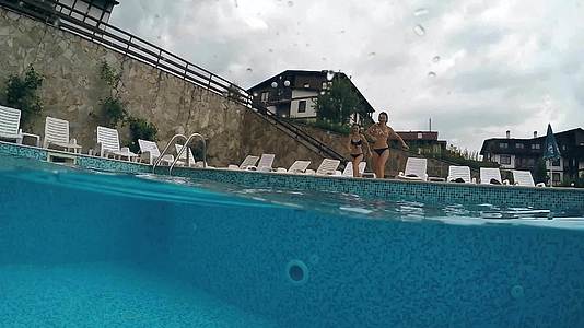 青少年在游泳池里跳跃Goprodme半水下视野慢动作视频的预览图