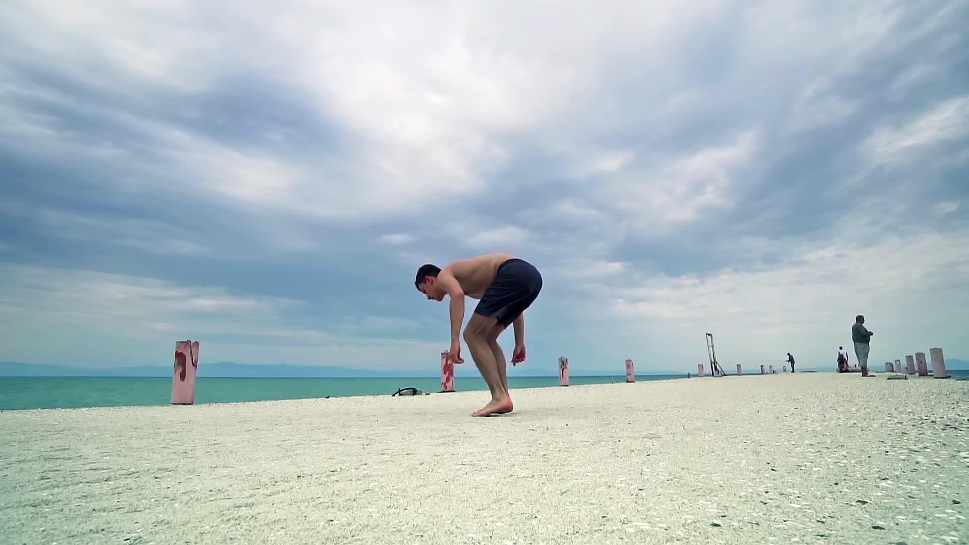 在海滩上跳高背翻转Parkour男人全身肖像视频的预览图