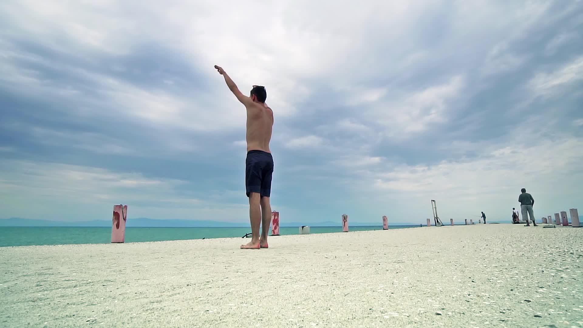 坐在海滩上跳高Parkour男子全身肖像完成后视频的预览图