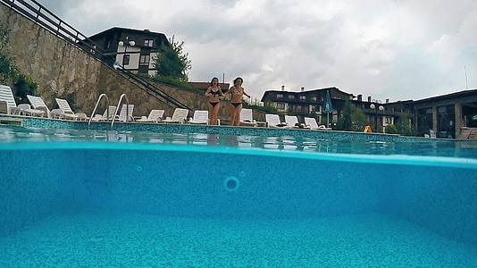 两个女孩跳进游泳池Goprodome电影慢动作射击视频的预览图