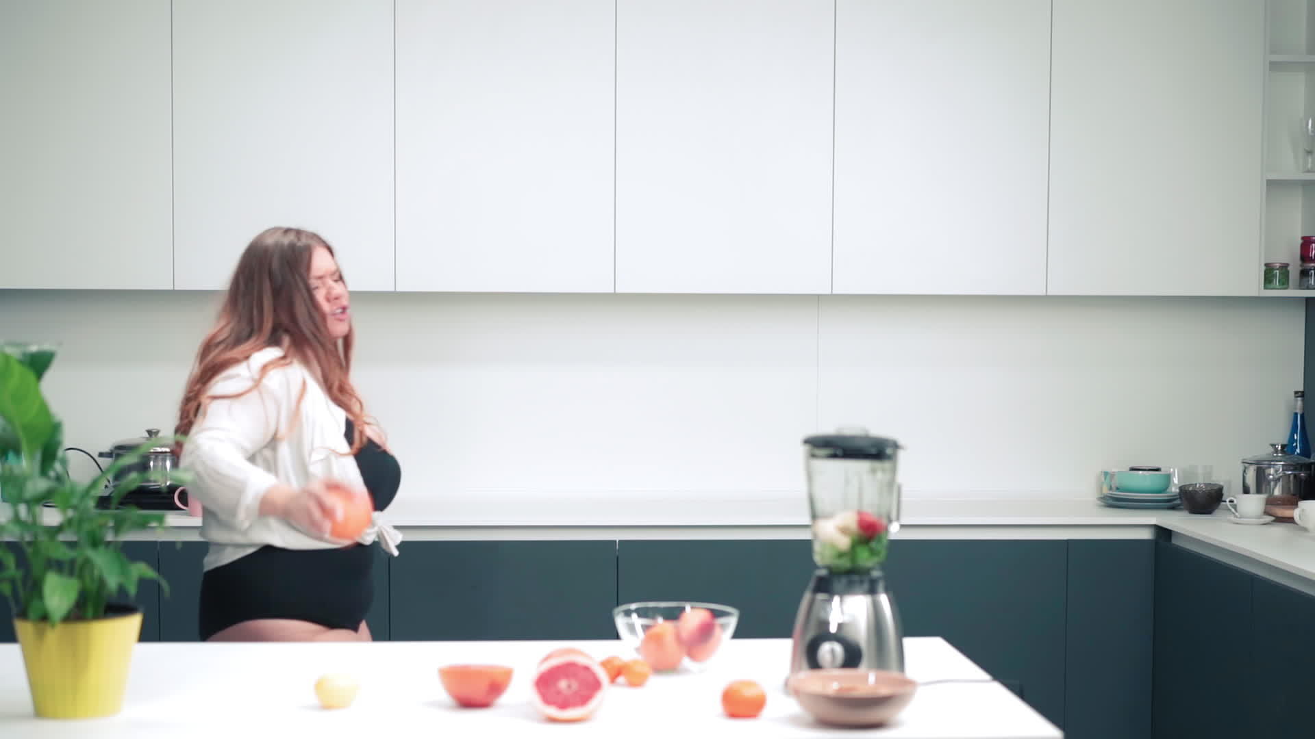 在厨房里快乐地跳舞手里拿着一个苹果身材曲线优美长长视频的预览图