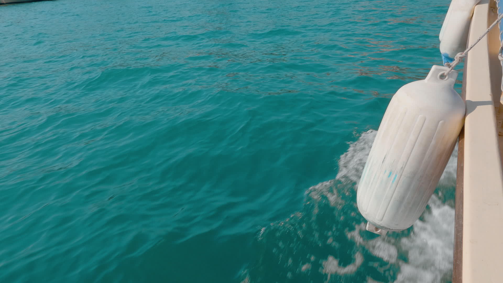 水蓝色的海水背景由带有泡沫和波浪的侧浮船拖着视频的预览图