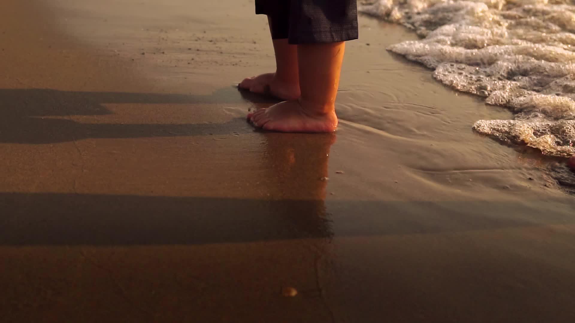 日落时在沙滩上散步慢慢地喷海浪视频的预览图