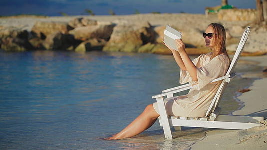 坐在海滩上的甲板椅上拍下海景的照片视频的预览图