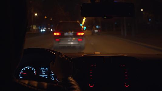 夜间驾驶第一视角车手在汽车方向盘上驾驶视频的预览图