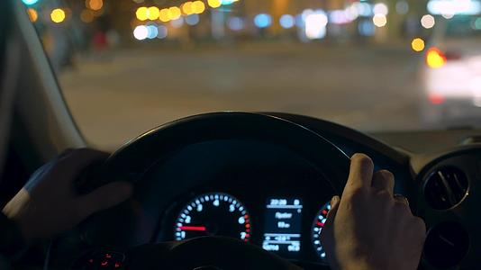 夜间驾驶第一视角车手在汽车方向盘上驾驶视频的预览图