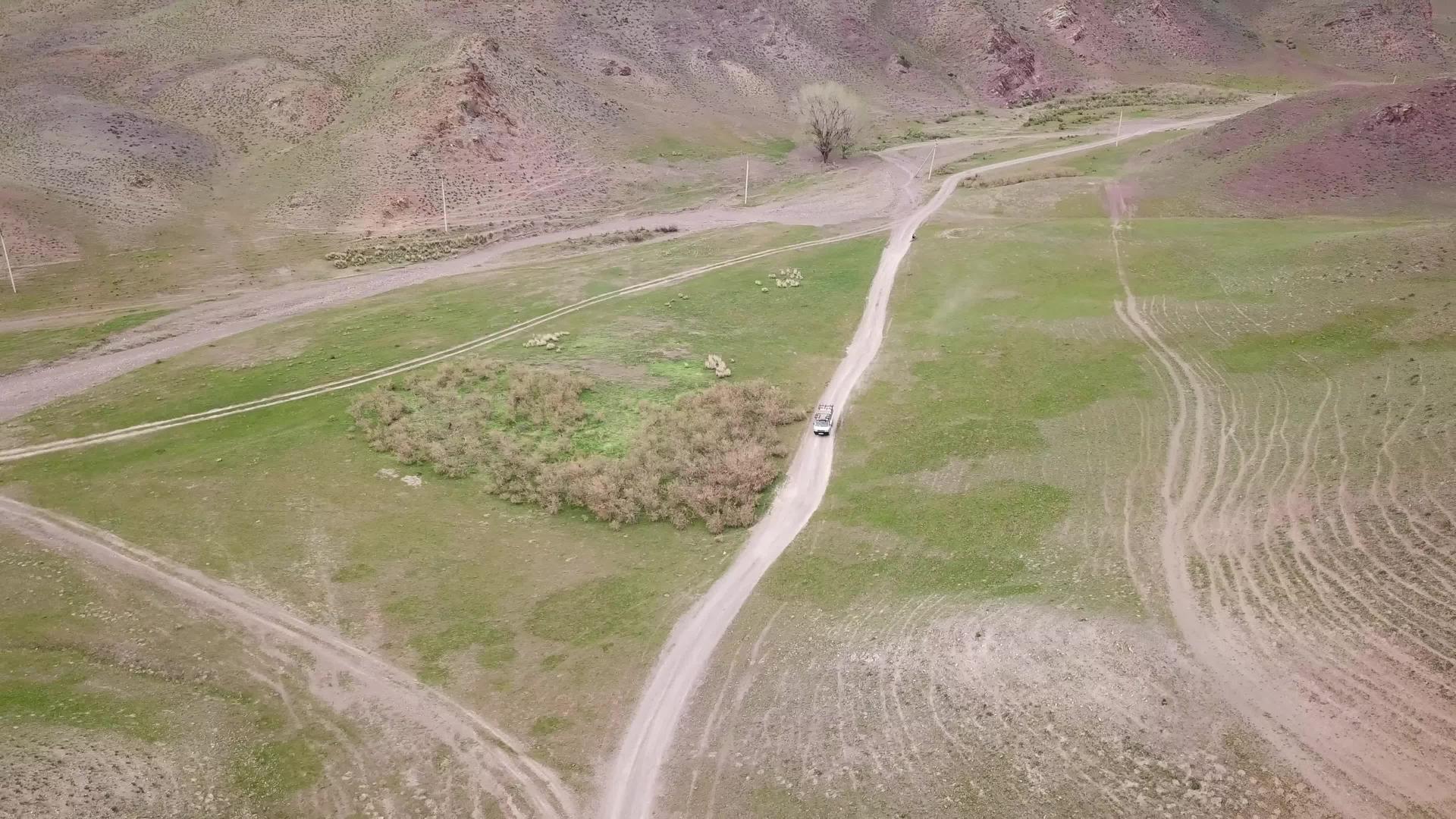 一辆小巴在绿色草原上行驶视频的预览图