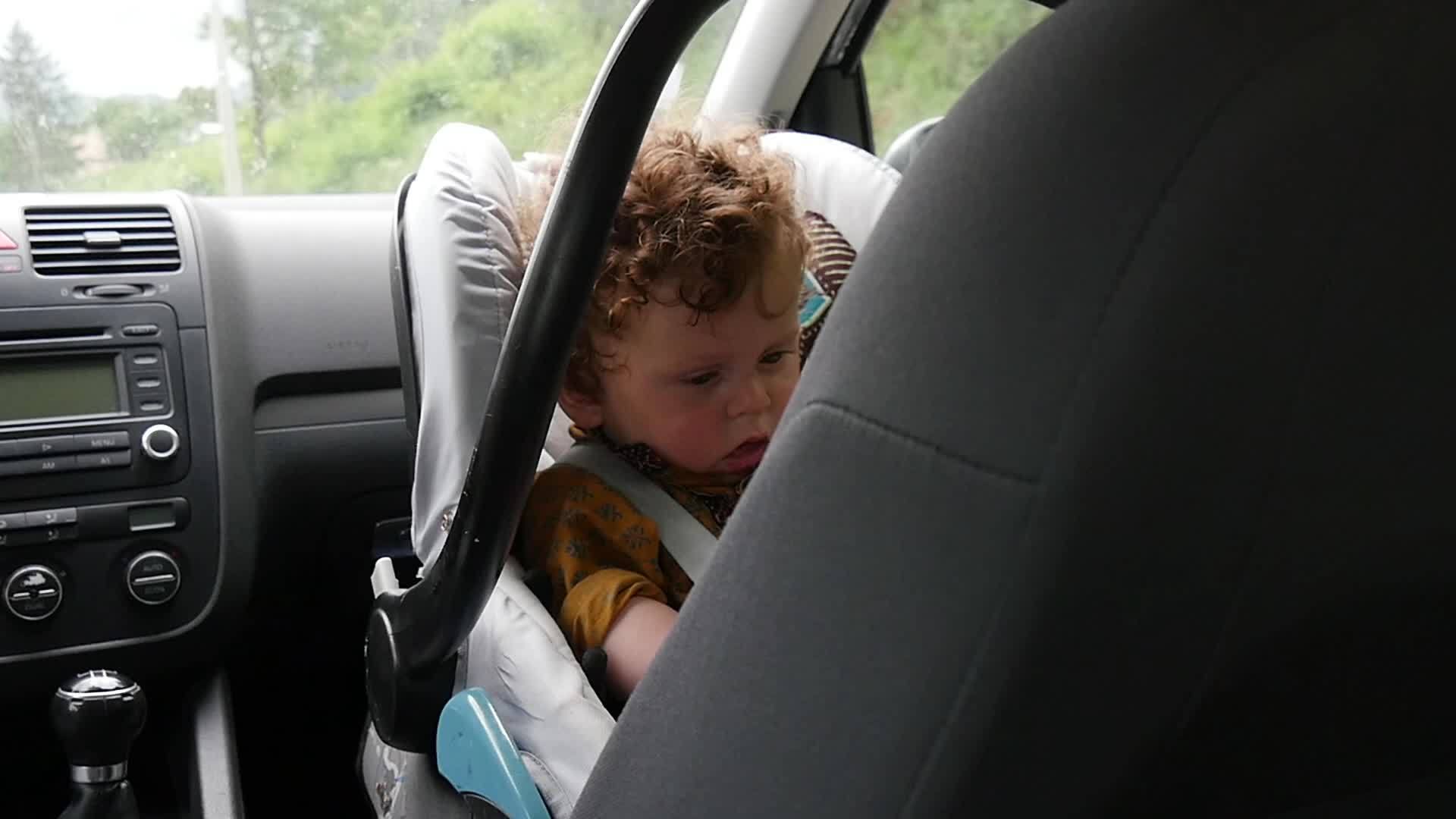 一个小男孩的肖像坐在汽车座椅上视频的预览图