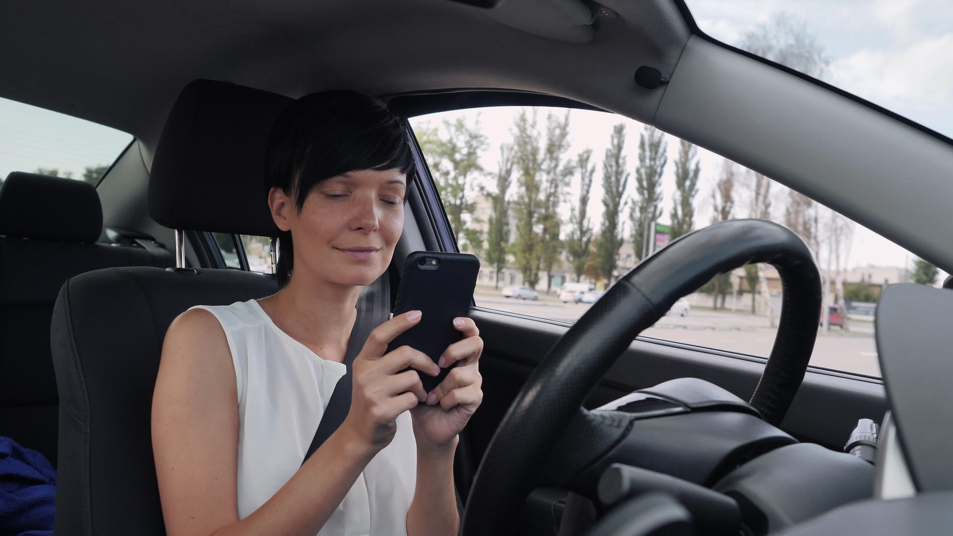 在停车场微笑的女性使用机动车视频的预览图
