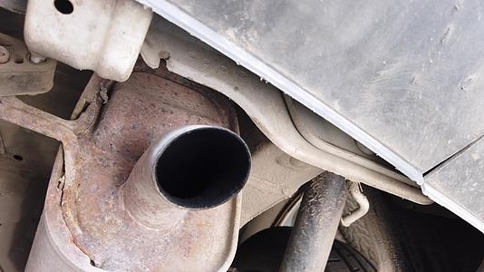 在维修过程中从排气管和催化剂的汽车底部拆卸的前部在车间内视频的预览图