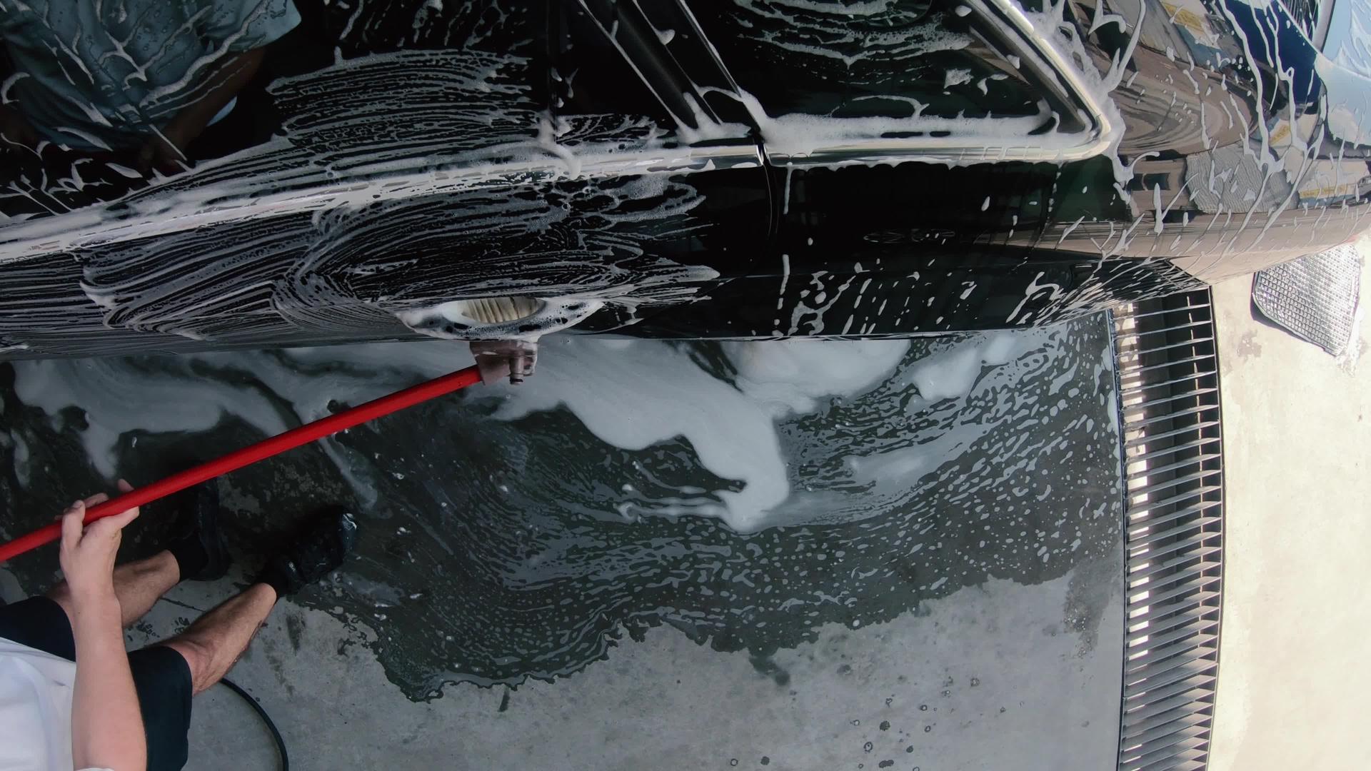 男性使用泡沫洗车和洗车刷服务视频的预览图