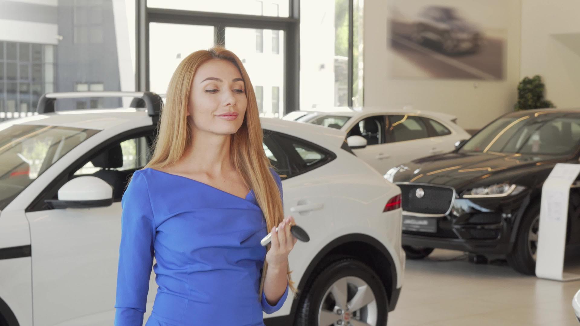 美丽快乐的女士在经销商处有车钥匙她的新车视频的预览图