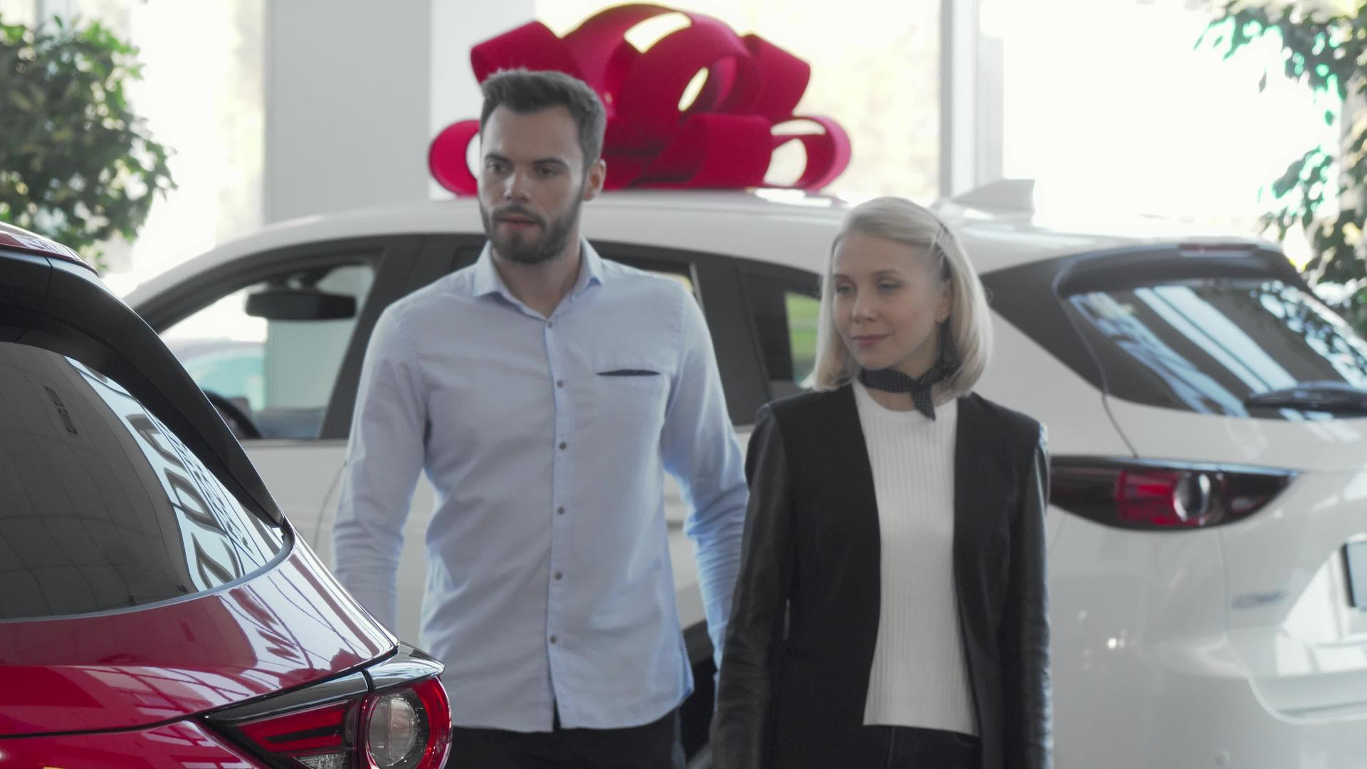 选择在汽车经销商购买的年轻夫妇视频的预览图