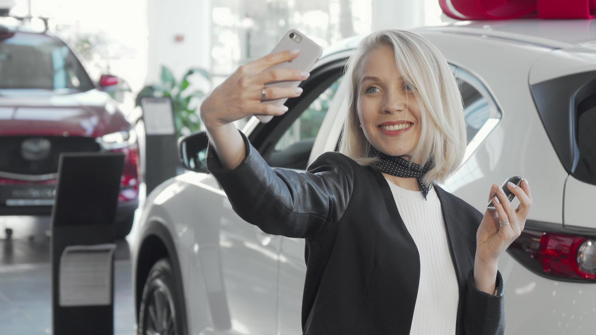 快乐的女士用她的新车钥匙在经销商店自拍视频的预览图