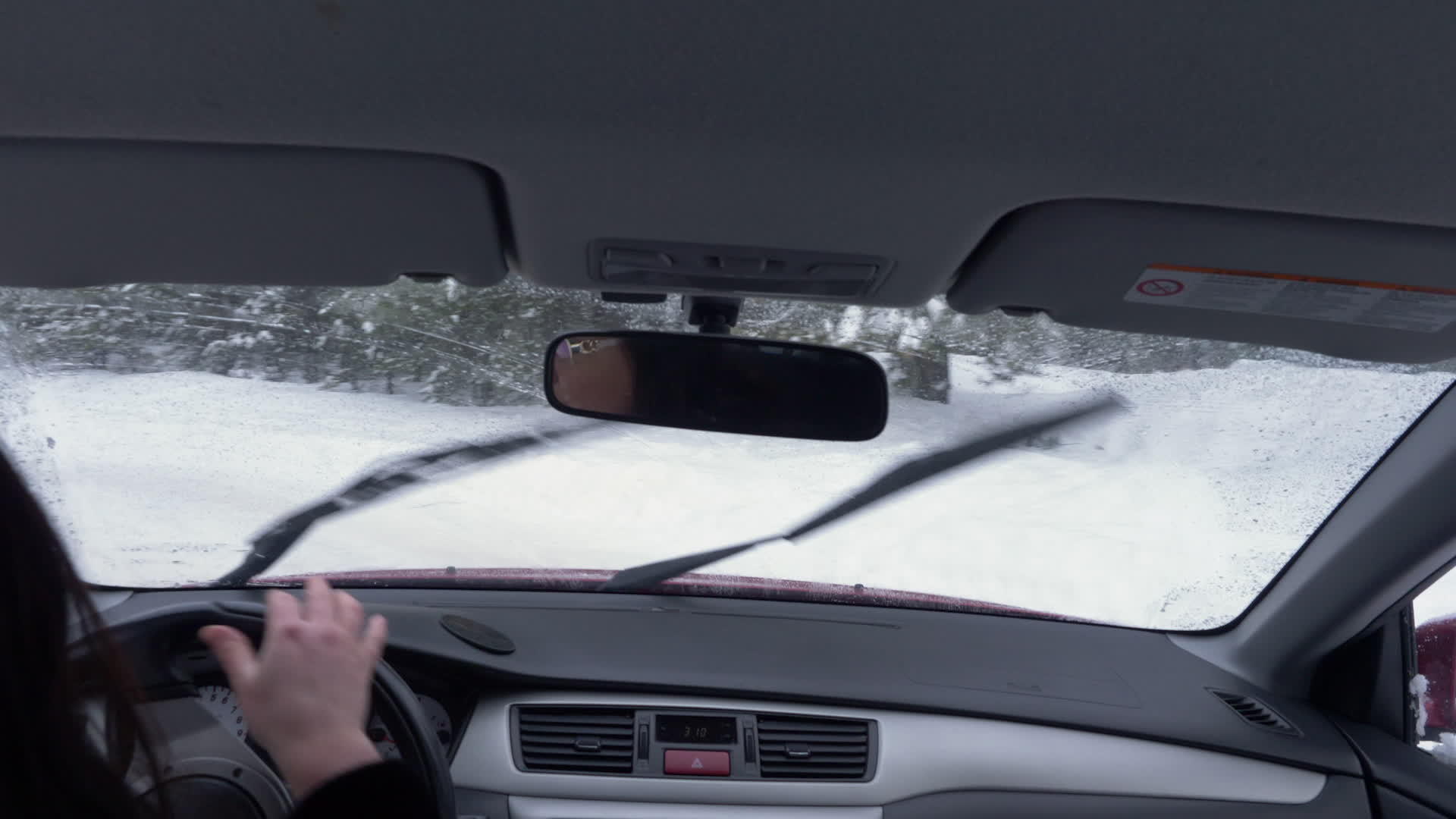 女人在冬天开车离开森林视频的预览图