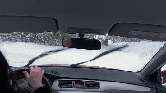 女人在冬天开车离开森林视频的预览图
